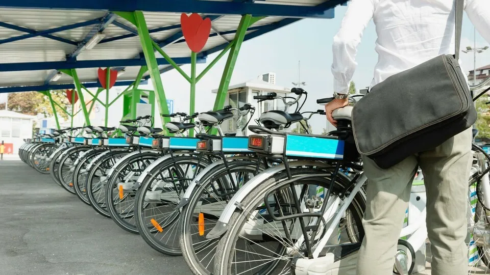 Office worker takes e-bike from bicycle sharing system station